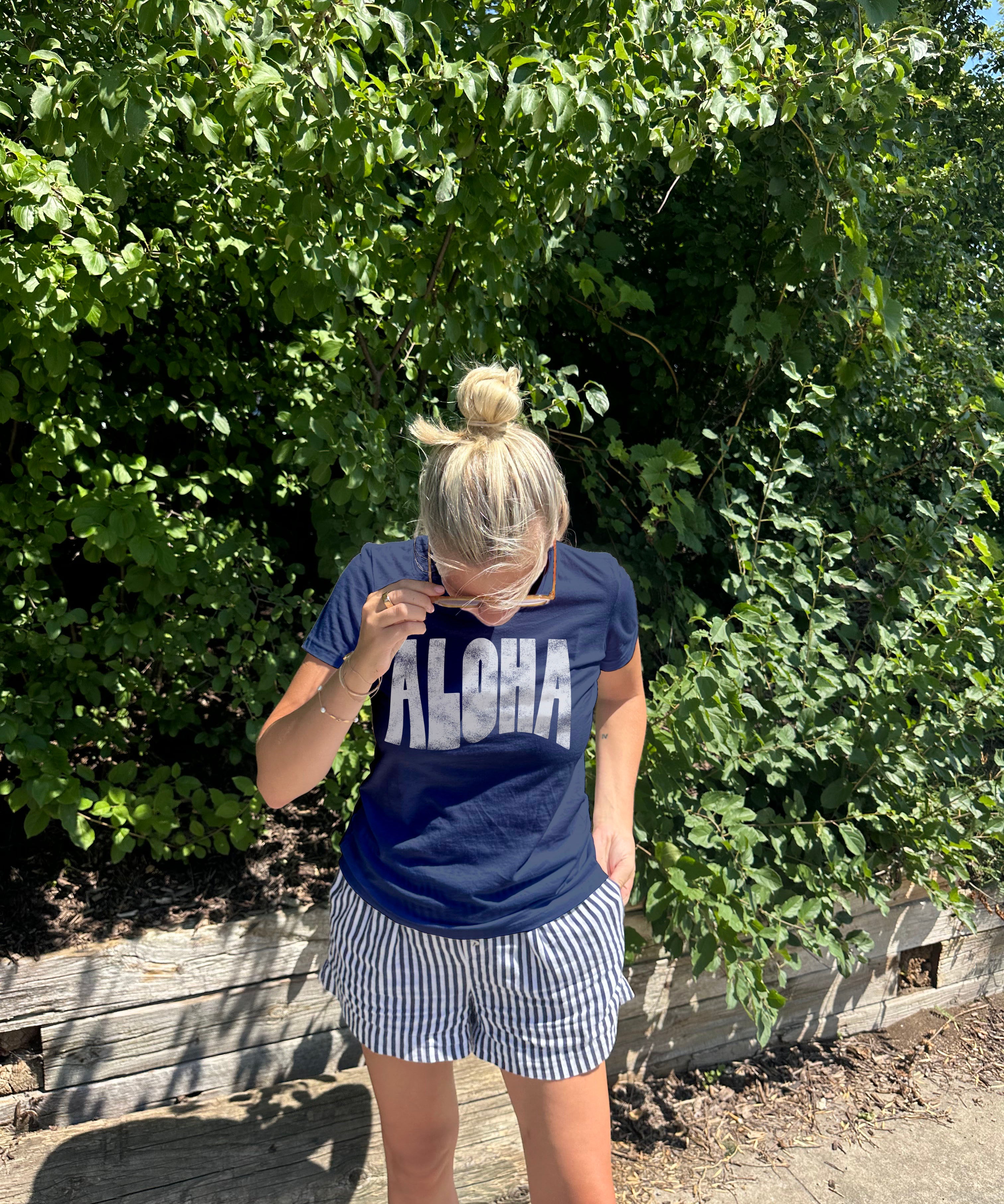 "Aloha" tee shirt in dark blue with white text on a  woman