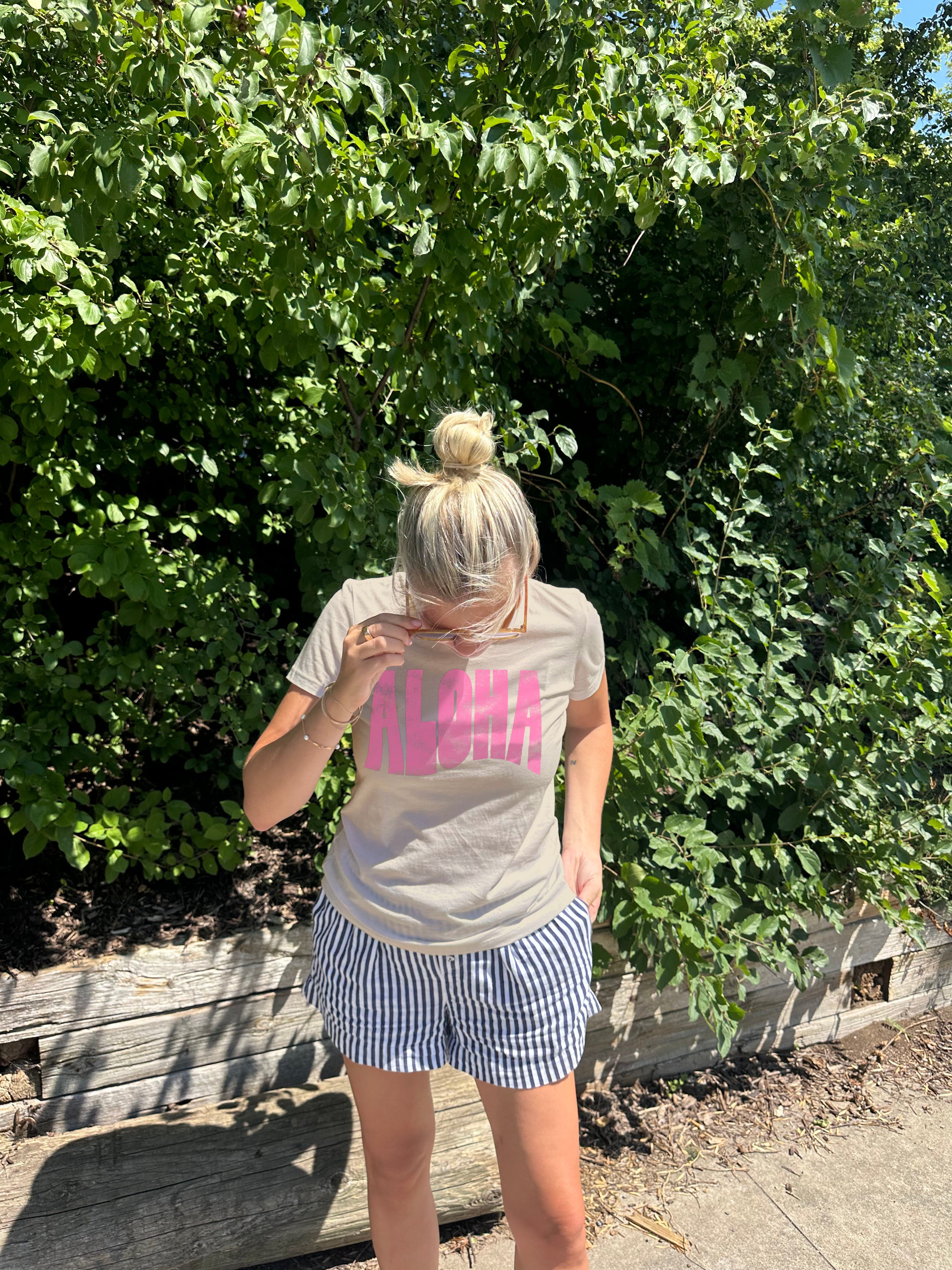 Woman in yellow tee shirt with "Aloha" i pink text