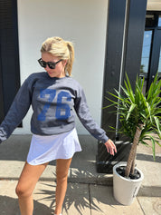 Grey crew neck sweater with blue numbers that say "76"