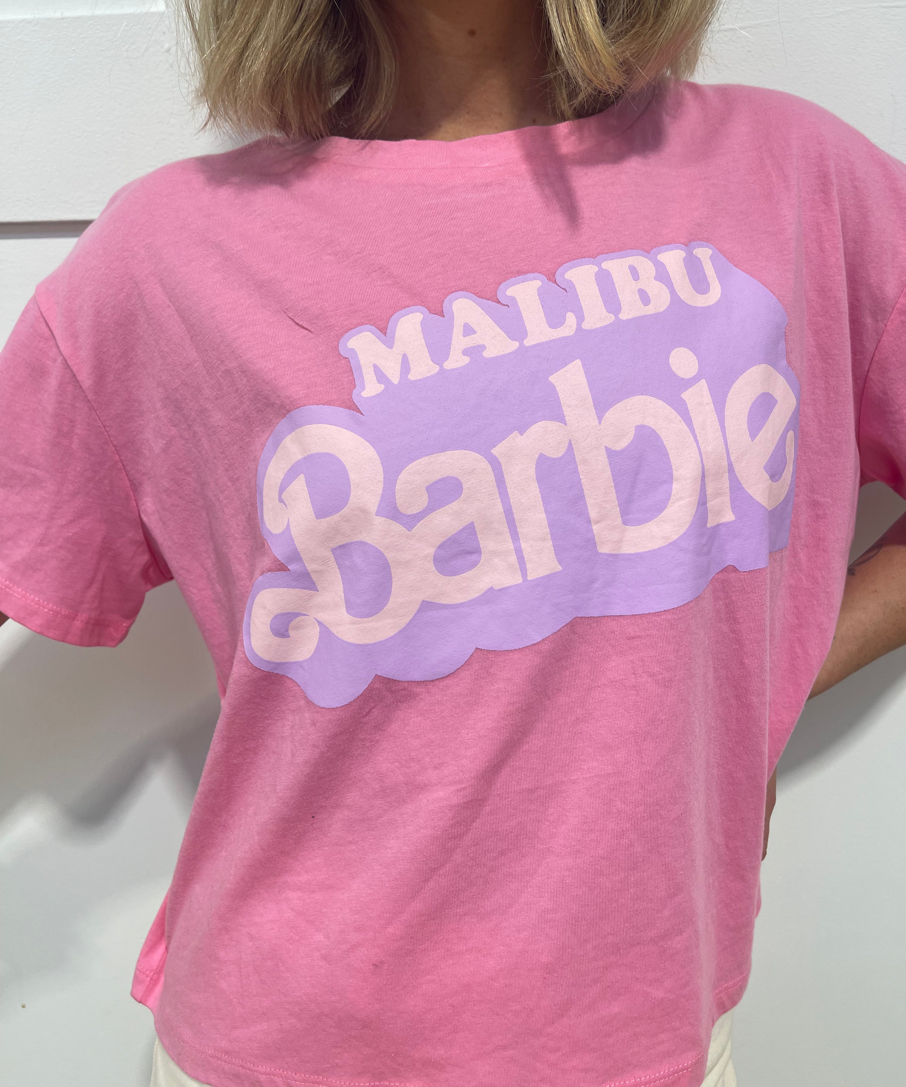 woman in pink Malibu barbie t shirt