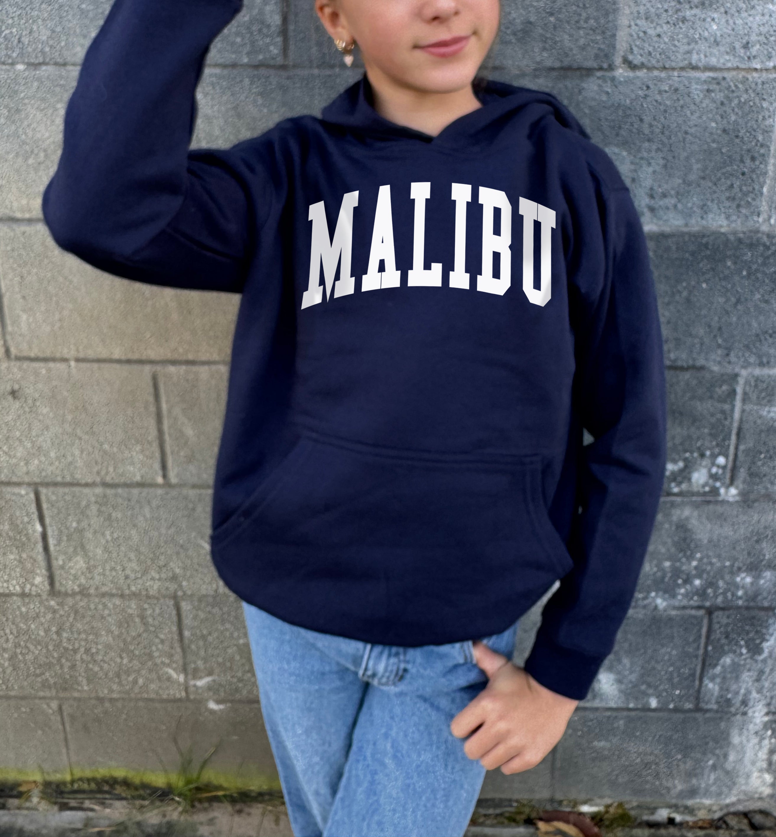 Girl in dark blue hoodie that says "Malibu" in white text