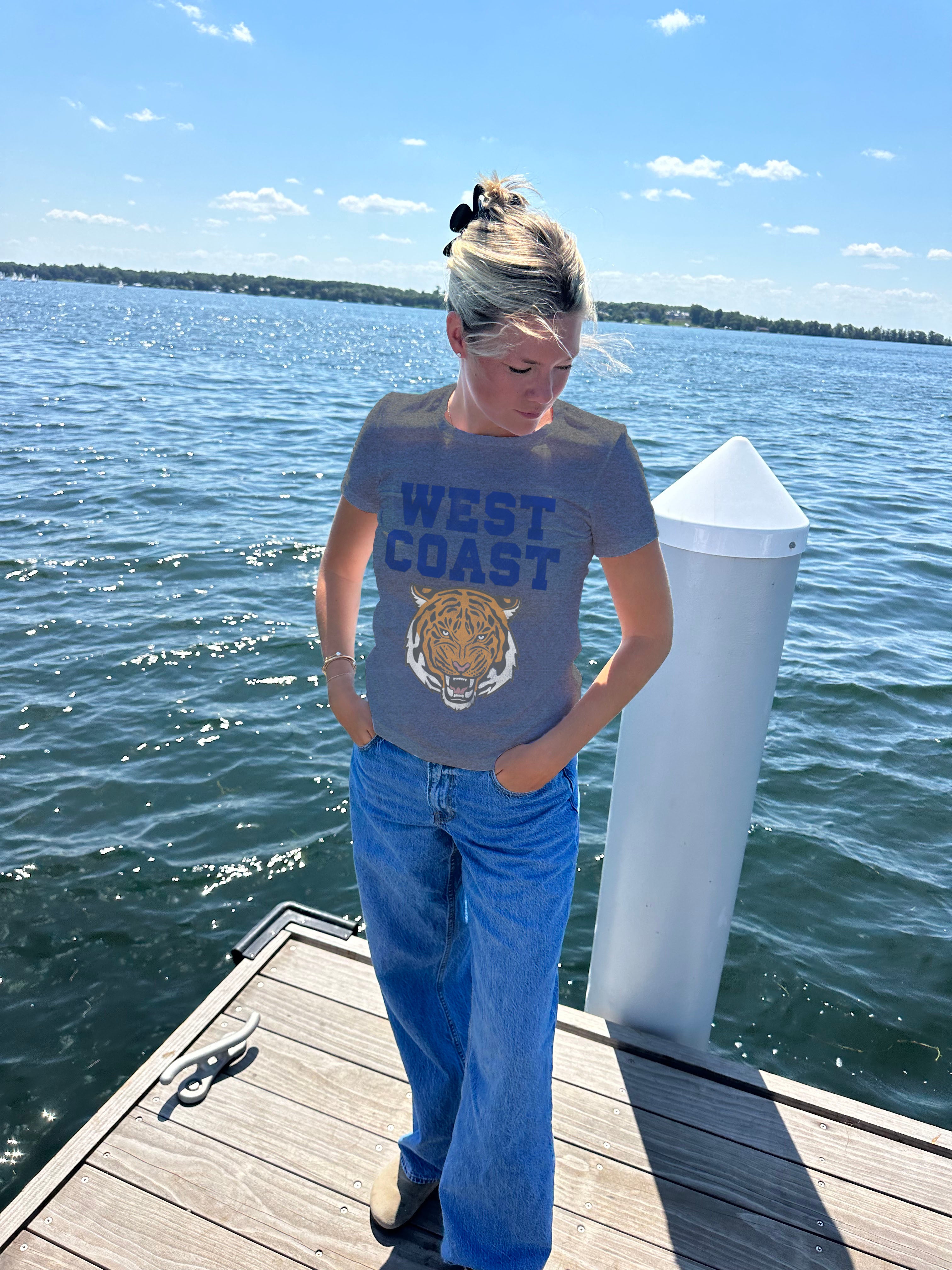 Grey tee shirt with blue lettering that says "West Coast" and ahs a tiger